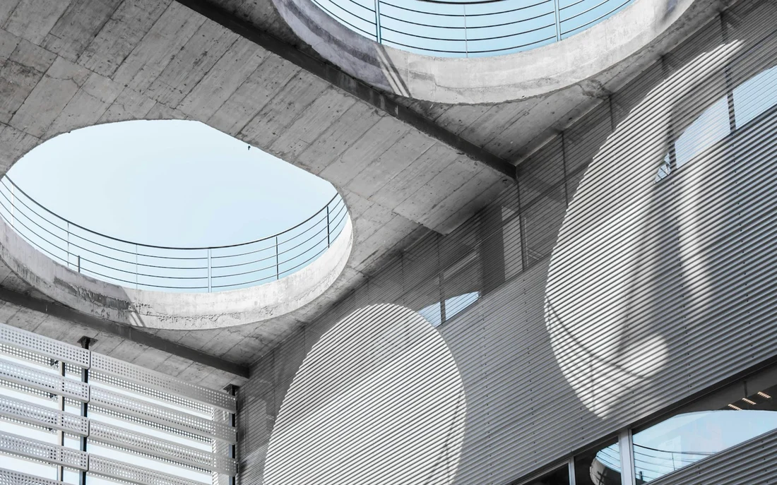 Atrium en béton éclairé par des puits de lumière ronds
